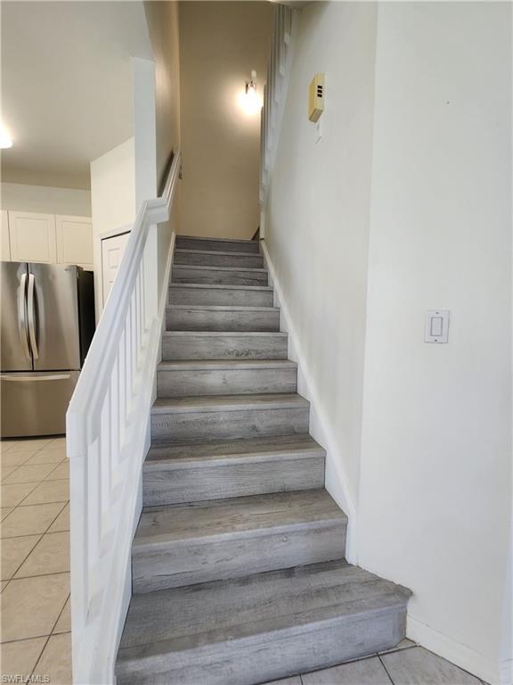 14708 Sutherland Avenue Naples, FL 34119 - Photo 8 of 24 Stairway featuring tile patterned flooring and baseboards