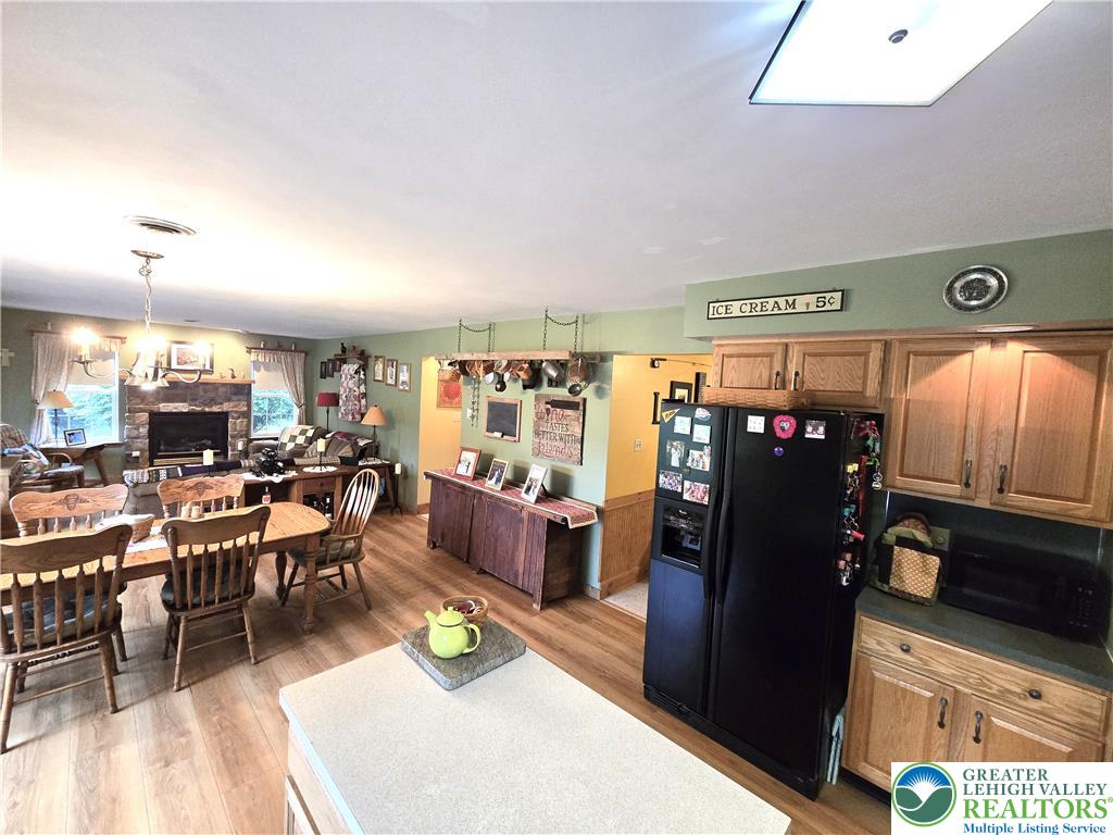 477 Quiet Valley Road Mount Bethel, PA 18343 - Photo 24 of 53 An open concept living space featuring a spacious kitchen area and a comfortable living room with a cozy stone fireplace.
