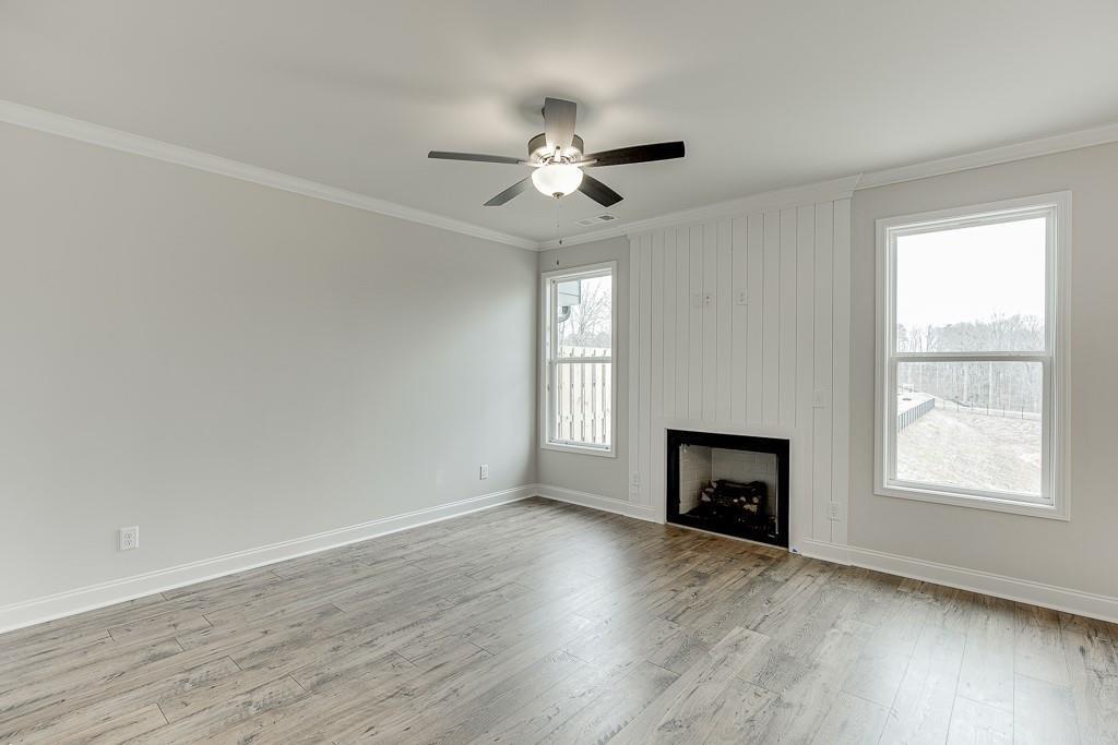 761 Woods Chapel Road Sugar Hill, GA 30518 - Photo 14 of 67 an empty room with wooden floor fireplace and windows