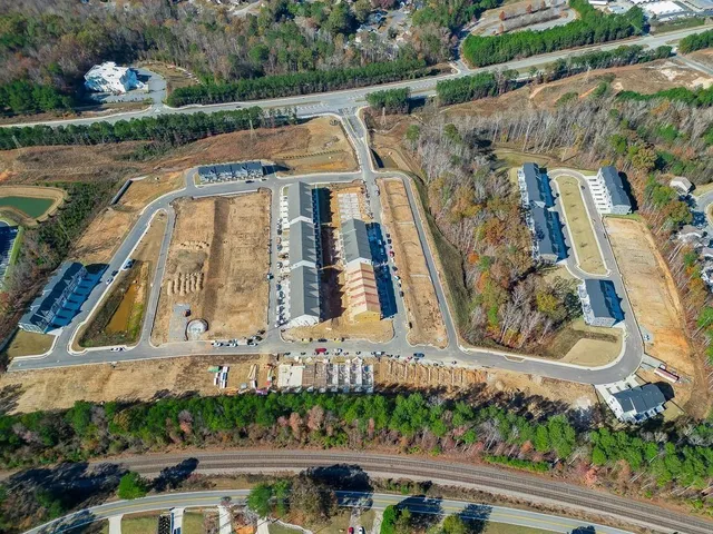 a pathway of a house with potted plants and a bench