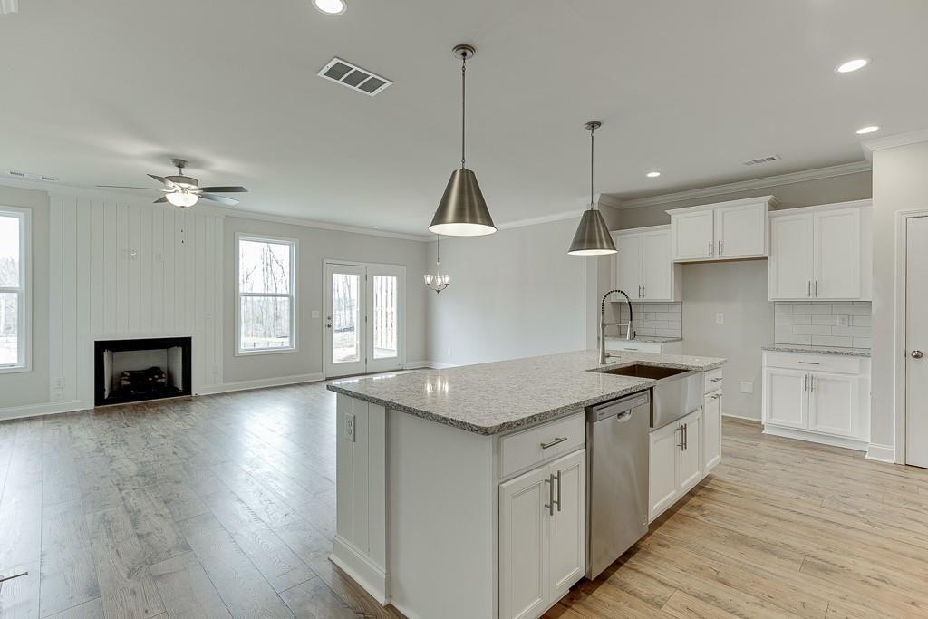 761 Woods Chapel Road Sugar Hill, GA 30518 - Photo 5 of 67 a kitchen with stainless steel appliances granite countertop a sink a stove and a wooden floors