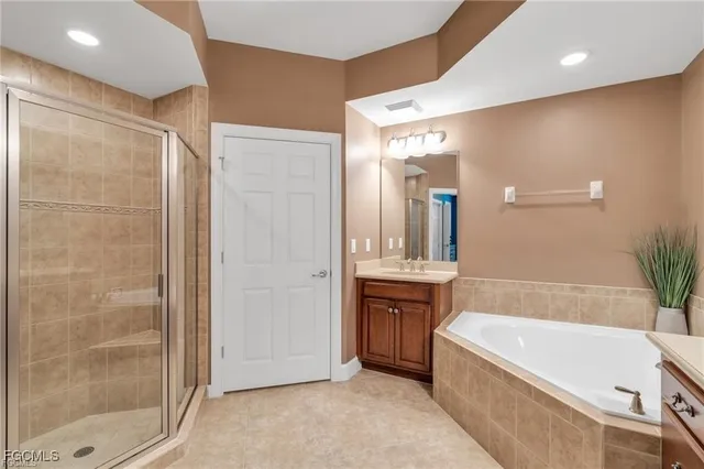 a spacious bathroom with a granite countertop tub shower and a mirror
