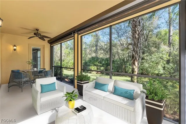 a living room with patio furniture and a floor to ceiling window