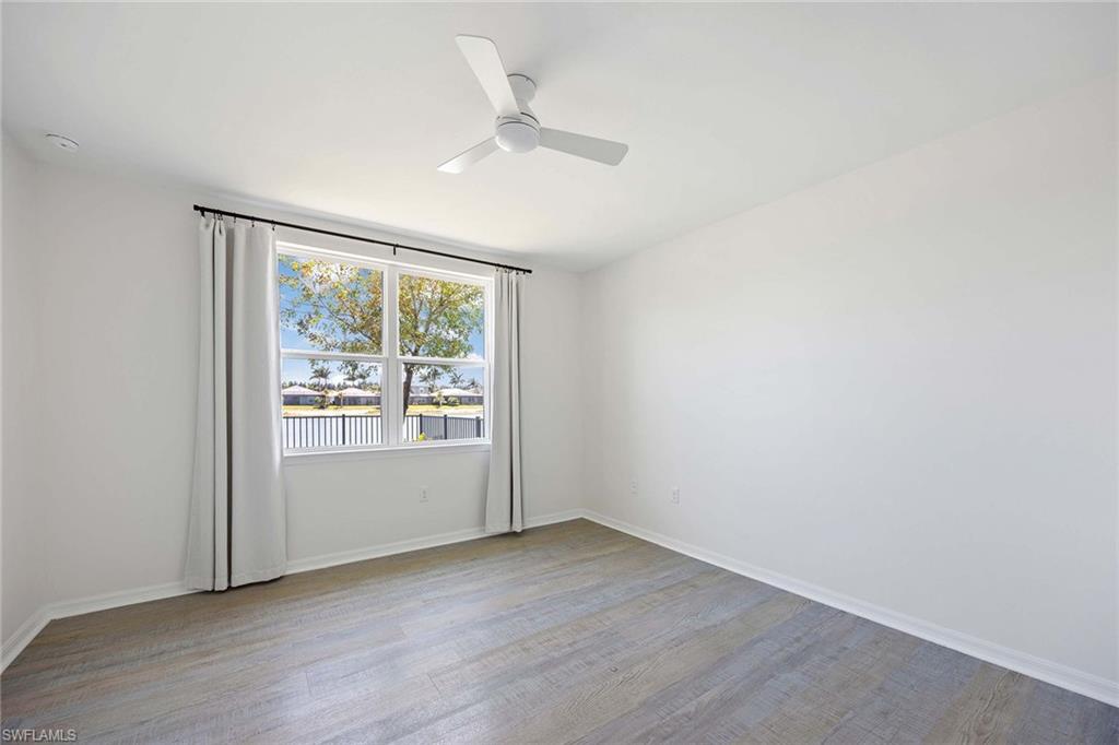 14799 Edgewater Circle Naples, FL 34114 - Photo 12 of 35 an empty room with wooden floor and windows