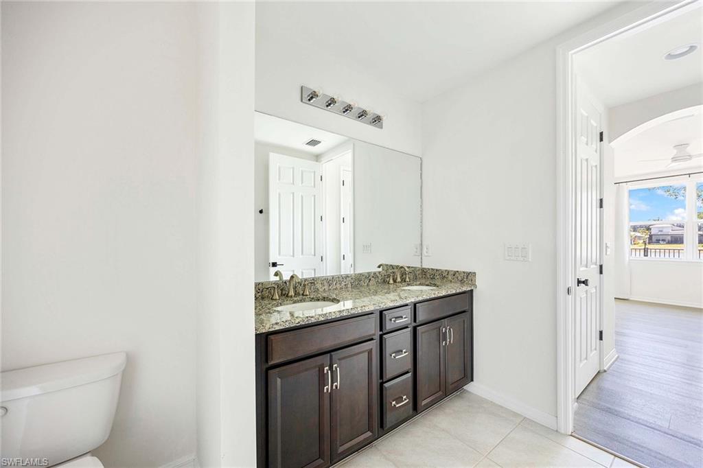 14799 Edgewater Circle Naples, FL 34114 - Photo 14 of 35 a spacious bathroom with a granite countertop sink and a mirror