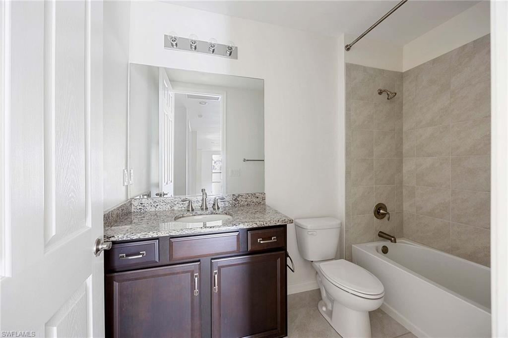 14799 Edgewater Circle Naples, FL 34114 - Photo 19 of 35 a bathroom with a granite countertop sink toilet and shower