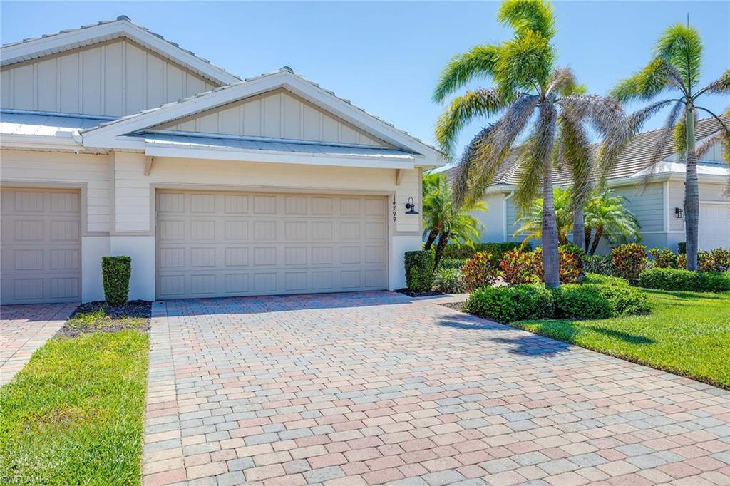 14799 Edgewater Circle Naples, FL 34114 - Photo 2 of 35 a front view of a house with a yard and garage