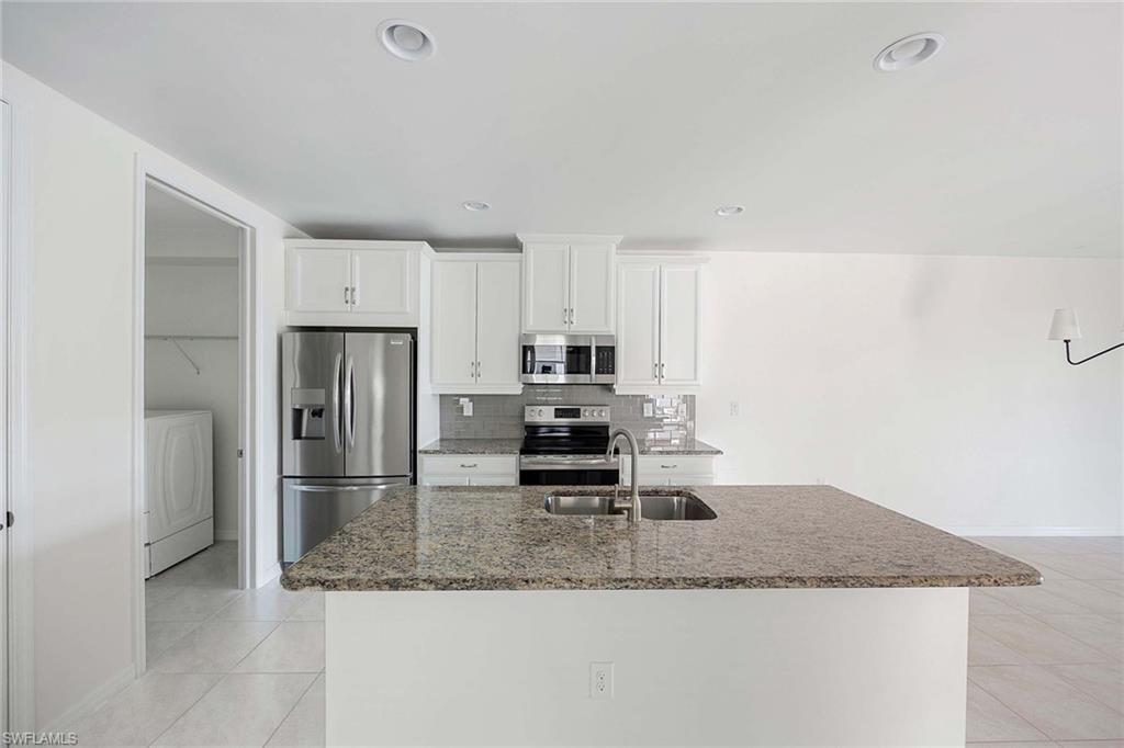 14799 Edgewater Circle Naples, FL 34114 - Photo 9 of 35 a kitchen with a refrigerator a microwave and sink
