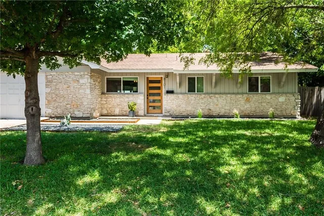 a front view of a house with a garden