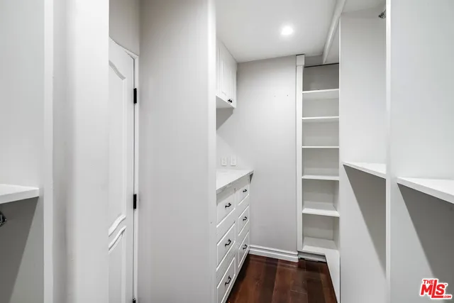 a view of walk in closet with empty racks