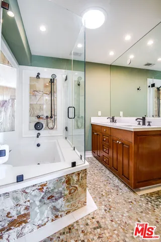 a spacious bathroom with a tub a sink and mirror