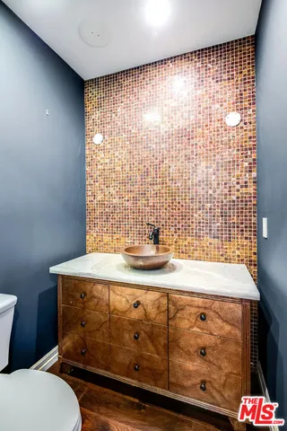 a bathroom with a granite countertop sink a toilet and shower