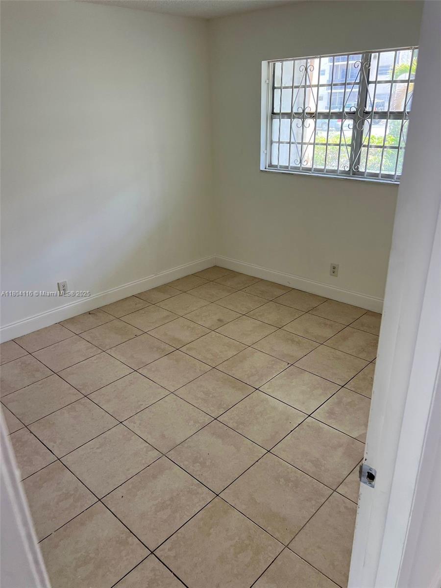 220 Southwest 9th Avenue, Unit 117 Hallandale Beach, FL 33009 - Photo 13 of 14 an empty room and chandelier