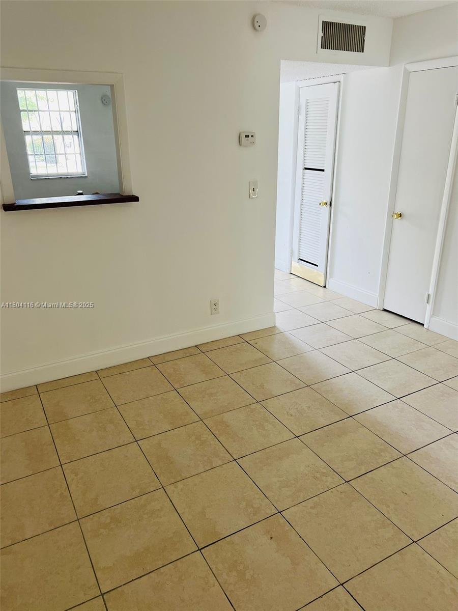 220 Southwest 9th Avenue, Unit 117 Hallandale Beach, FL 33009 - Photo 2 of 14 an empty room with windows