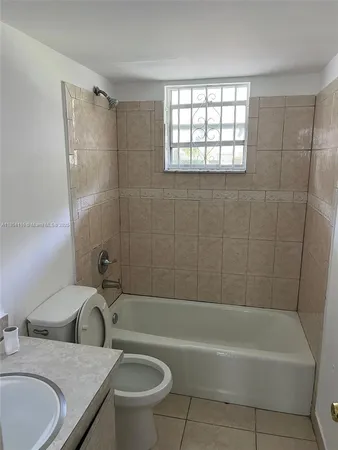 a bathroom with a granite countertop sink a toilet and bathtub