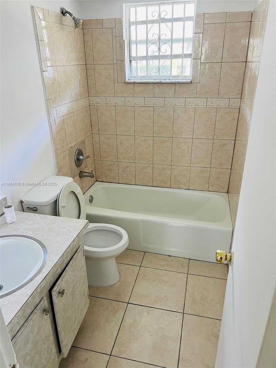 220 Southwest 9th Avenue, Unit 117 Hallandale Beach, FL 33009 - Photo 6 of 14 a bathroom with a granite countertop bathtub sink vanity mirror and toilet