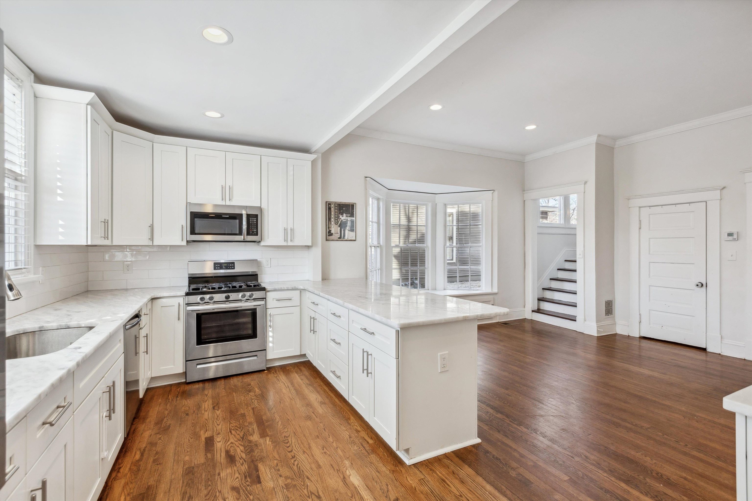 779 Roland Street Memphis, TN 38104 - Photo 11 of 29 a kitchen with stainless steel appliances granite countertop a stove top oven a sink dishwasher a refrigerator and white cabinets with wooden floor