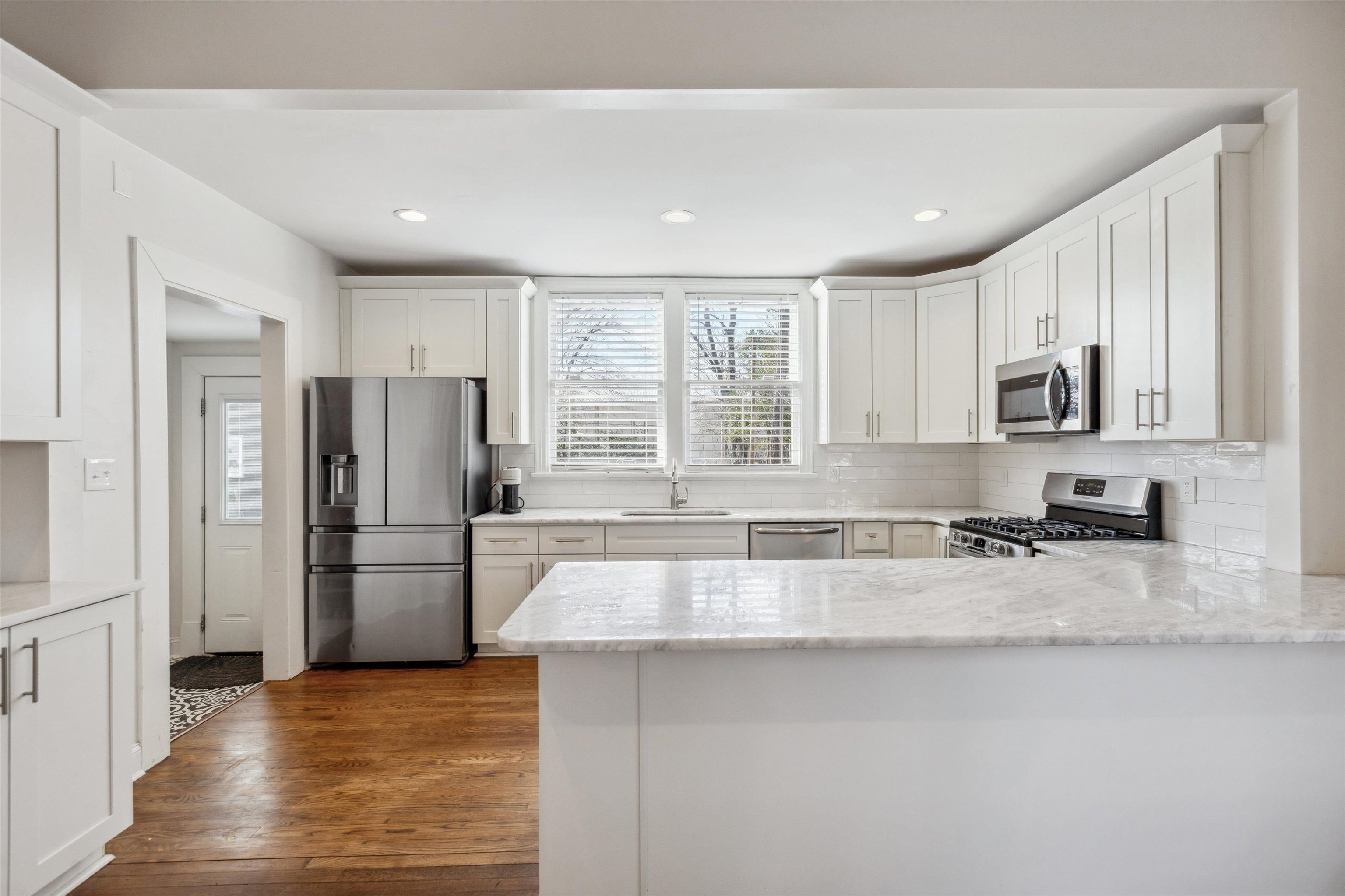 779 Roland Street Memphis, TN 38104 - Photo 10 of 29 a kitchen with a refrigerator a microwave a sink and cabinets