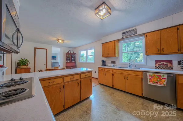 a large kitchen with stainless steel appliances granite countertop a stove a sink and a microwave