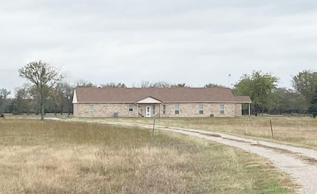 a view of an house with a yard and a large tree