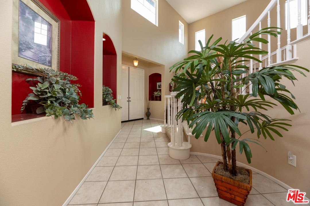 6847 Raspberry Court Eastvale, CA 92880 - Photo 10 of 49 a vase of flowers sitting on a floor in front of a house