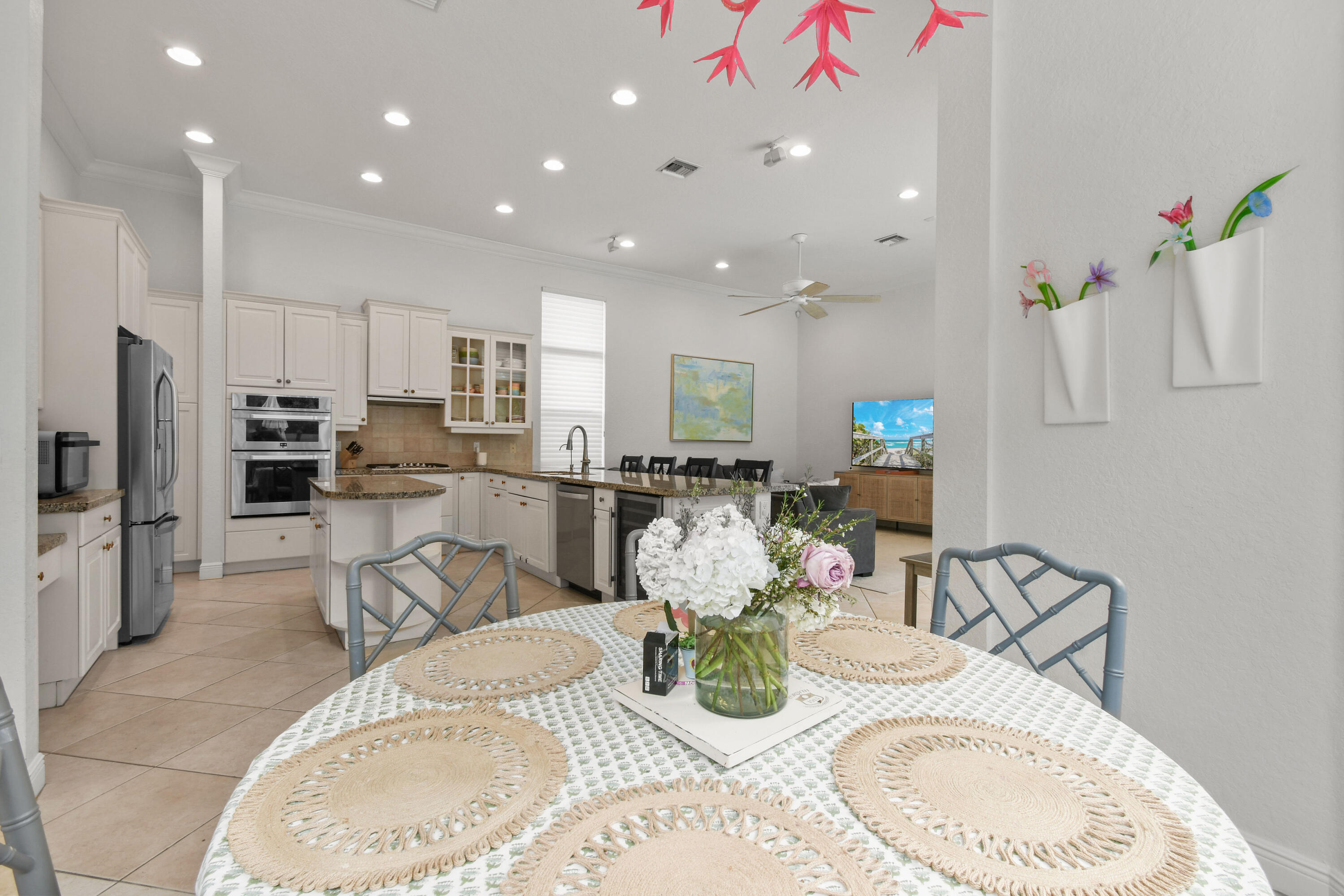 111 Bilboa Drive Jupiter, FL 33458 - Photo 15 of 35 a kitchen with stainless steel appliances kitchen island granite countertop a dining table chairs and refrigerator