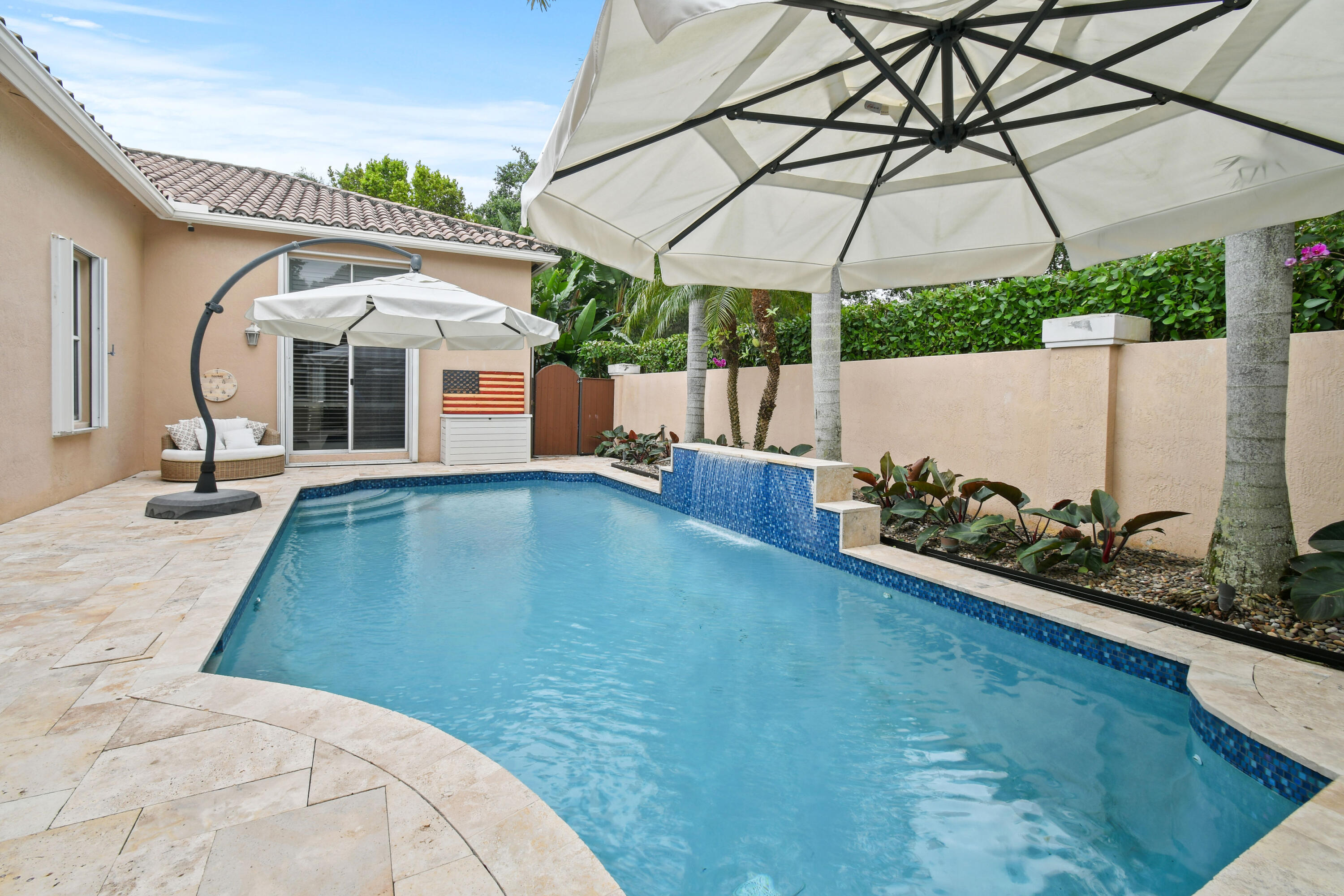 111 Bilboa Drive Jupiter, FL 33458 - Photo 31 of 35 a view of a patio with a table and chairs under an umbrella