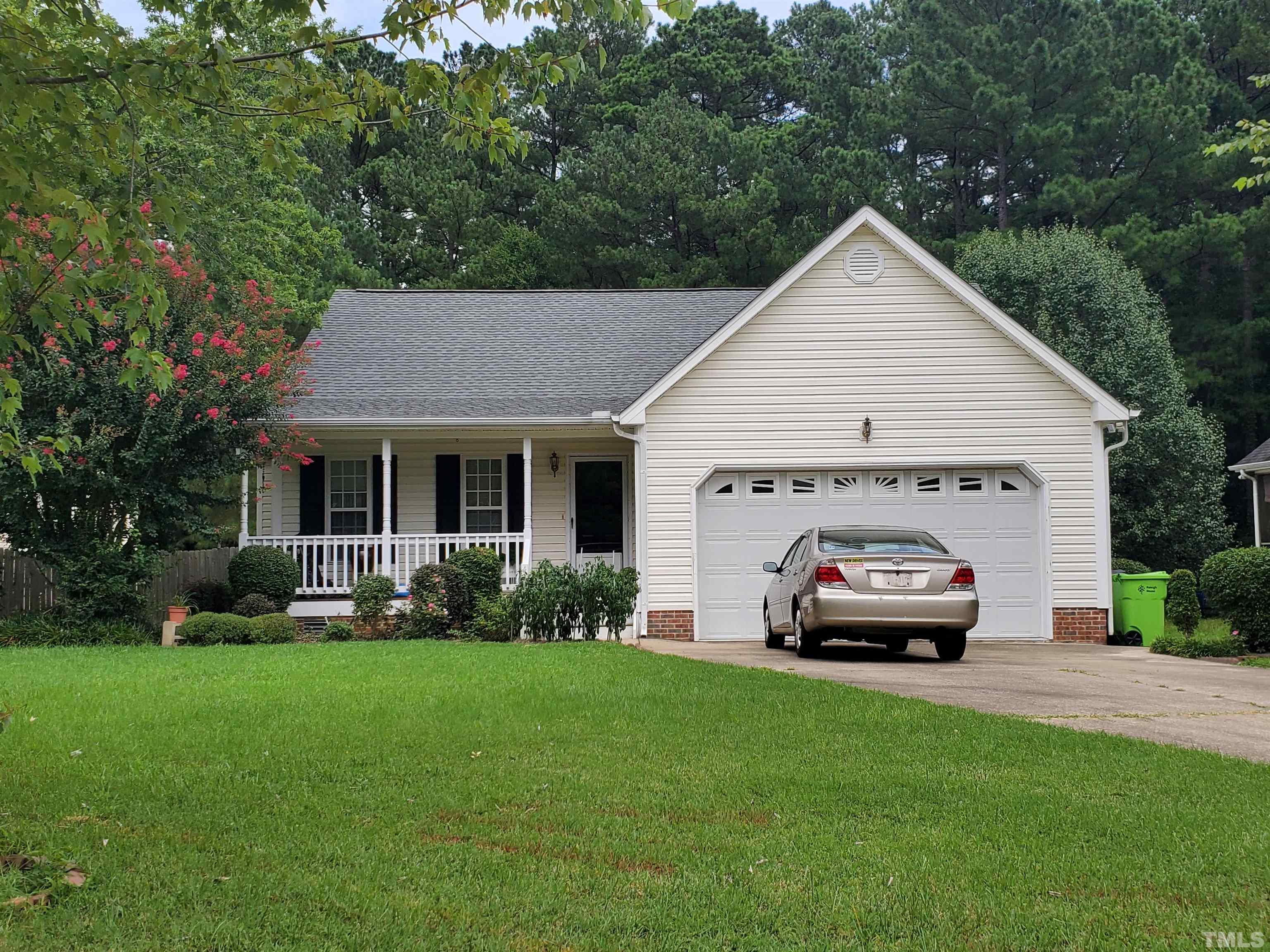 a car parked in front of house with a yard