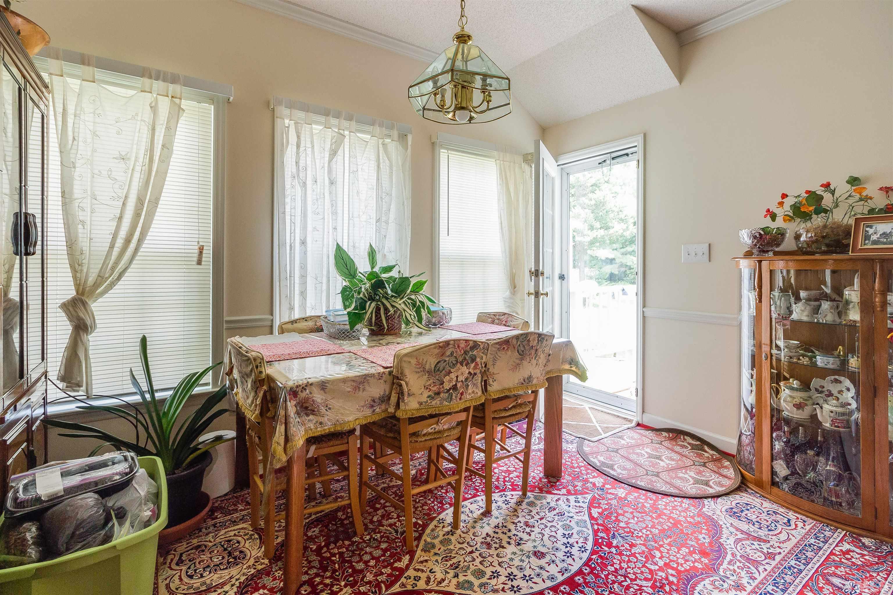 4216 Wolftrap Road Raleigh, NC 27616 - Photo 4 of 20 a dining room with furniture potted plants and wooden floor