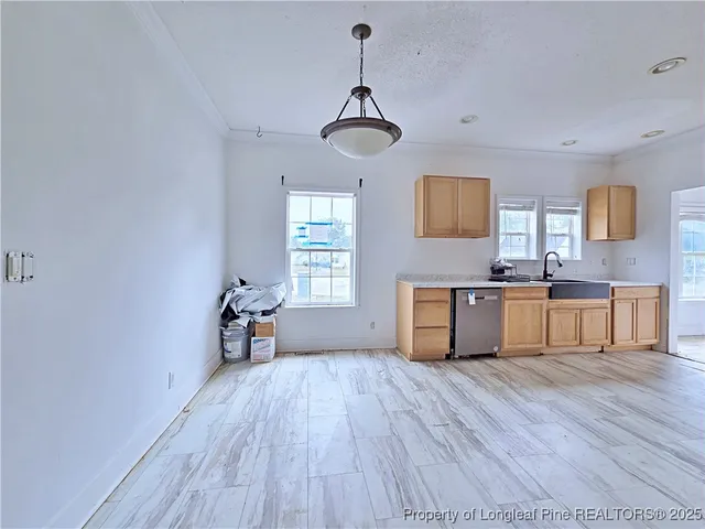 a view of a kitchen with a sink dishwasher microwave oven and next to a window