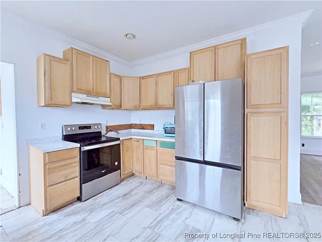 a kitchen with a refrigerator sink and wooden cabinets