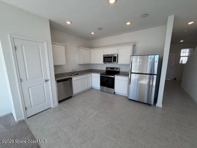 a kitchen with cabinets and stainless steel appliances