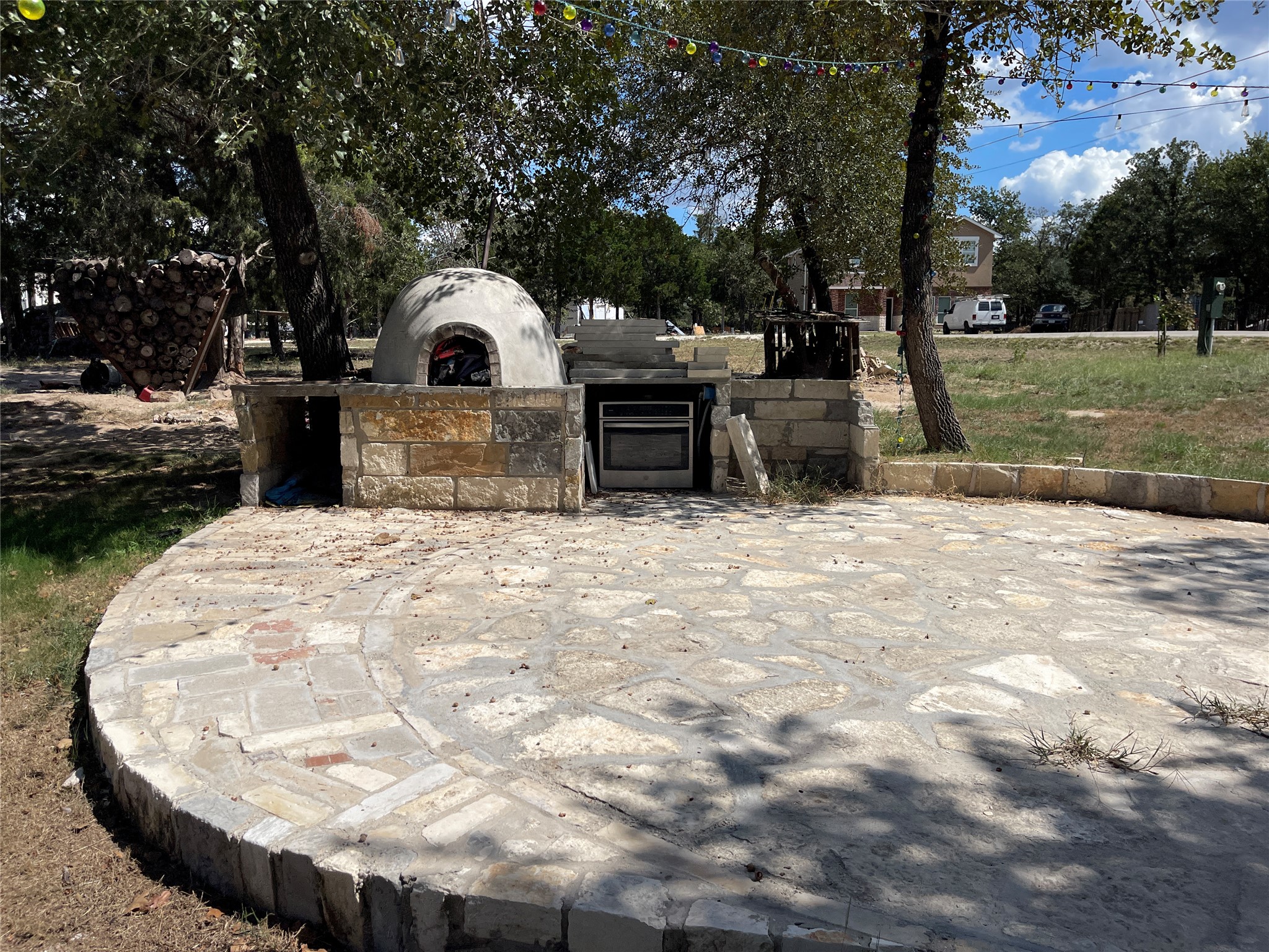 103 Azalea Avenue Elgin, TX 78621 - Photo 20 of 23 A spacious stone patio showcases a custom outdoor kitchen with a built-in pizza oven.