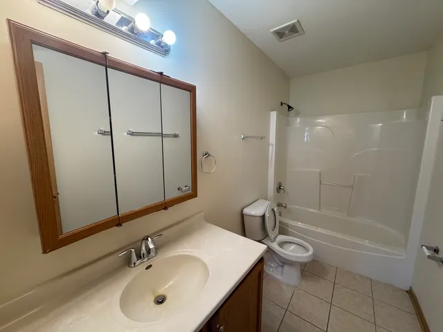 a bathroom with a sink a toilet a mirror and shower
