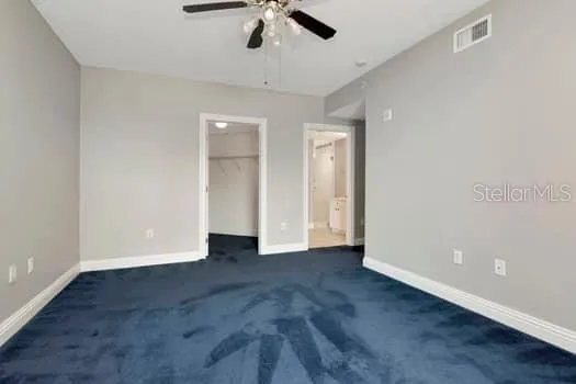 a spacious bedroom with a bed a window and dresser