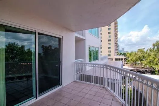 a view of a balcony with a floor to ceiling window and wooden fence