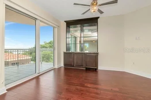 a view of empty room with wooden floor and fan