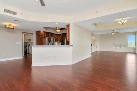 a view of a kitchen with wooden floor and a refrigerator