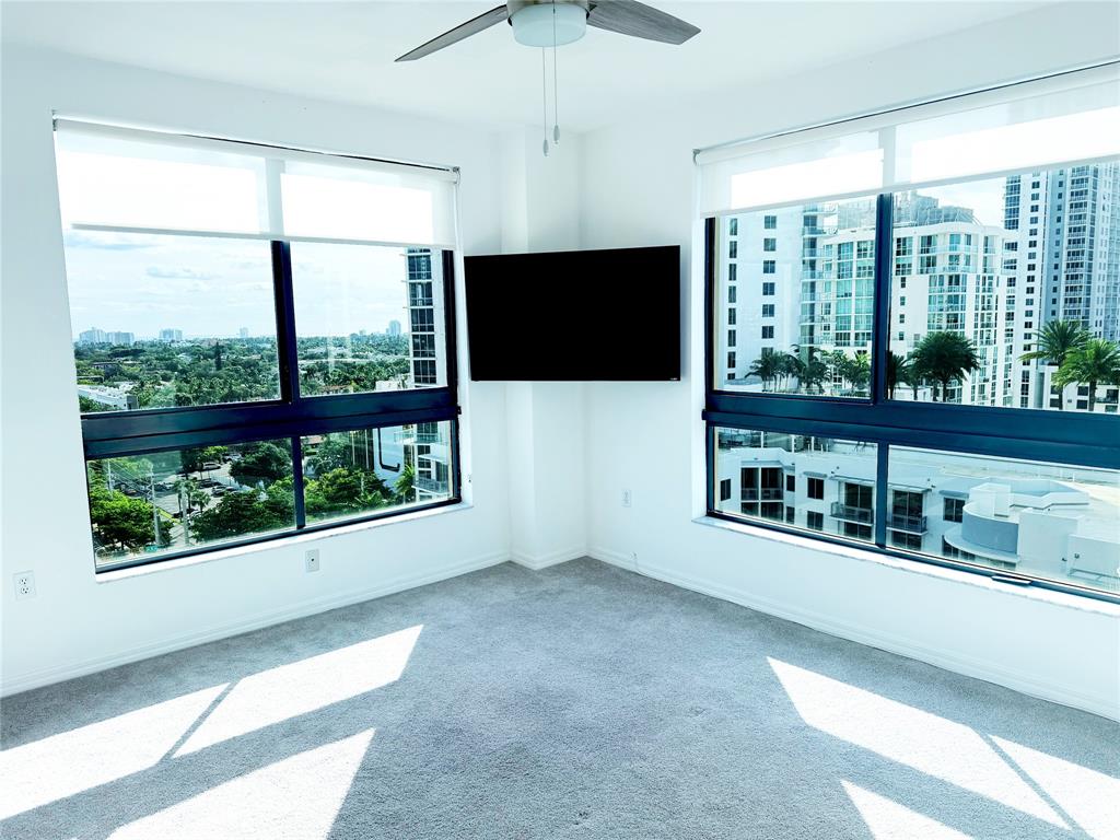 a living room with large windows and a flat screen tv