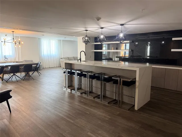 a large kitchen with lots of counter space a sink and chairs