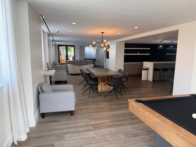 a living room with couches and kitchen view with wooden floor