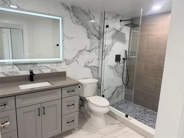 a bathroom with a sink a toilet and shower