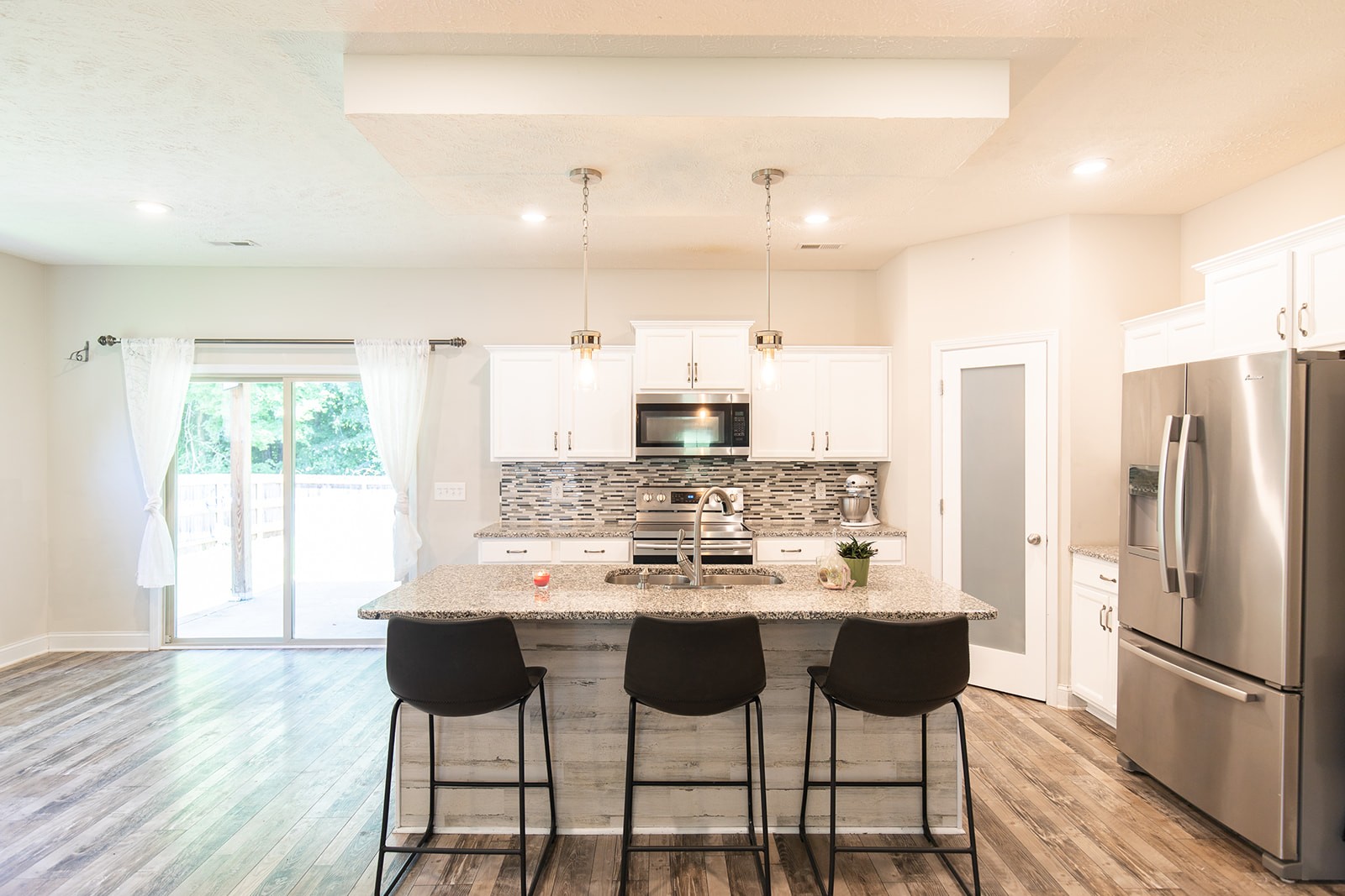 1045 Fuji Lane Clarksville, TN 37040 - Photo 5 of 24 a kitchen with stainless steel appliances kitchen island granite countertop a dining table chairs and white cabinets