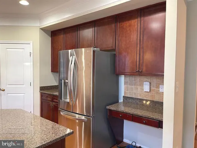 a kitchen with stainless steel appliances granite countertop a refrigerator and a stove top oven