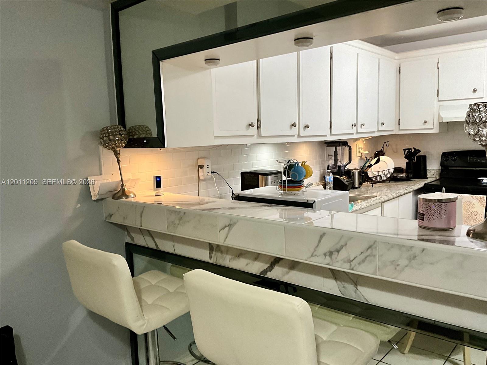 1910 West 56th Street, Unit 3226 Hialeah, FL 33012 - Photo 16 of 21 a kitchen with stainless steel appliances white cabinets and a sink