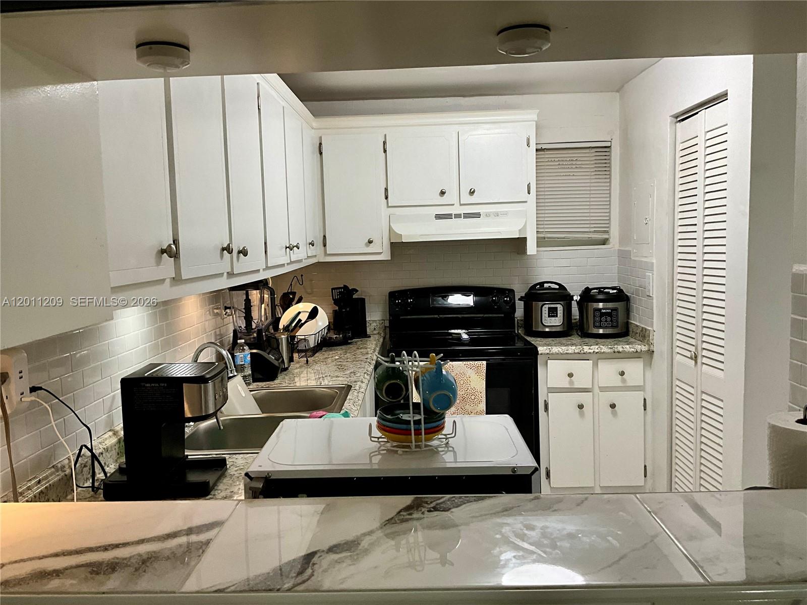 1910 West 56th Street, Unit 3226 Hialeah, FL 33012 - Photo 17 of 21 a kitchen with a white cabinets and appliances