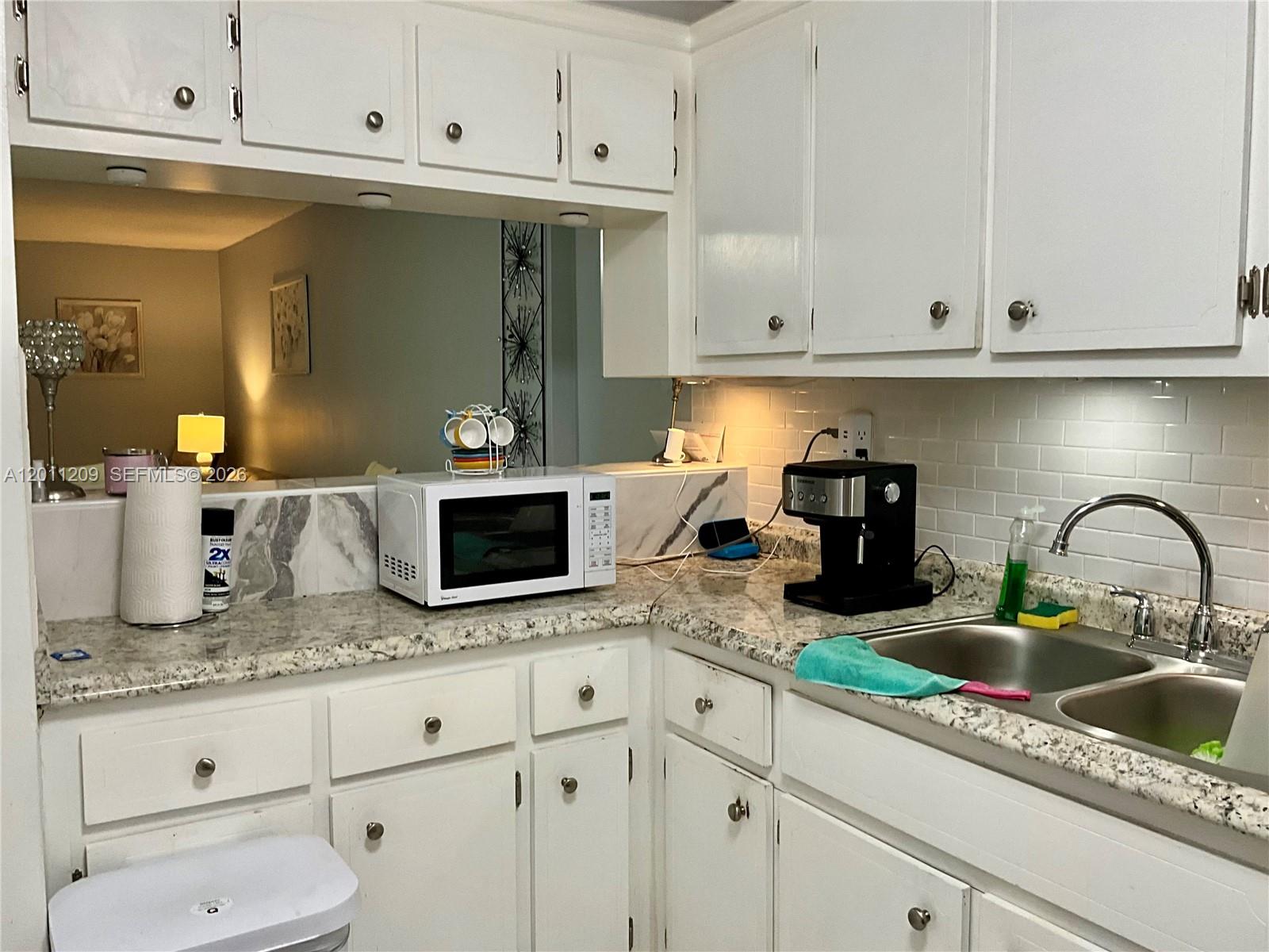 1910 West 56th Street, Unit 3226 Hialeah, FL 33012 - Photo 18 of 21 a kitchen with granite countertop white cabinets and sink