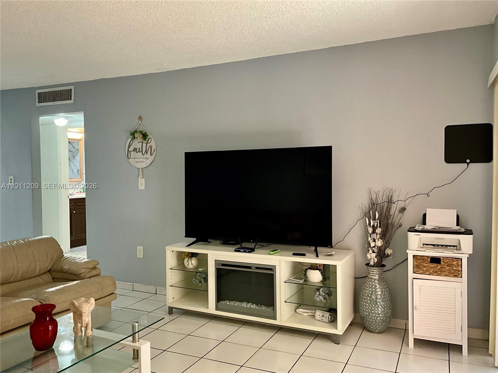 1910 West 56th Street, Unit 3226 Hialeah, FL 33012 - Photo 6 of 21 a living room with a flat screen tv and washer