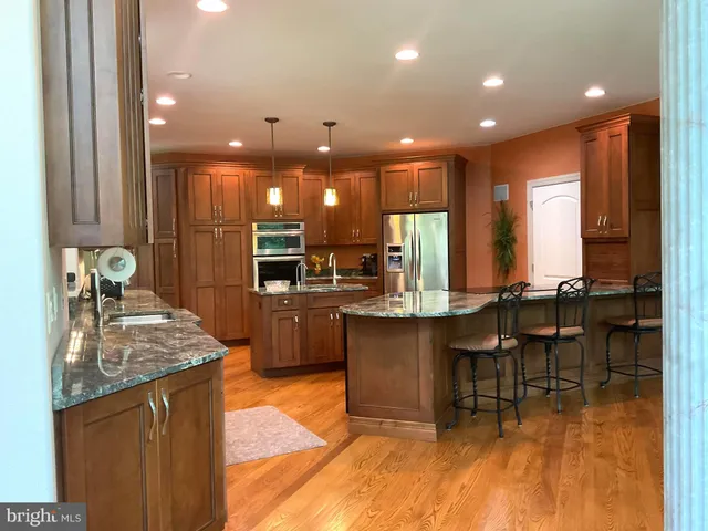 a kitchen with granite countertop wooden cabinets and stainless steel appliances