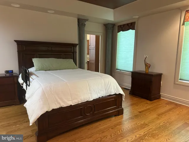 a bedroom with a bed and wooden floor